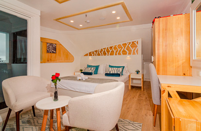 Cabina Suite Matrimonial con balcón del Yate Sea Star Galápagos con una cama de dos plazas, ventanas panorámicas, sala de estar, escritorio.