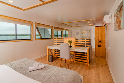 Cabina Suite Matrimonial del Yate Sea Star Galápagos con una cama de dos plazas y ventanas panorámicas